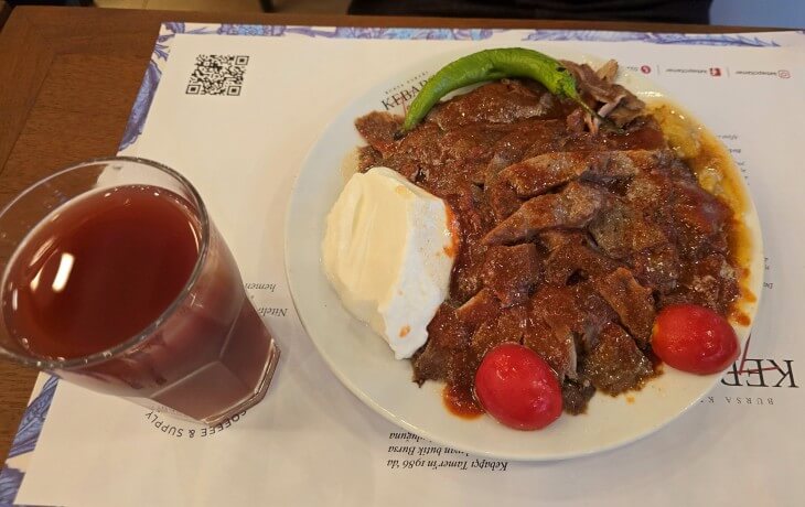 Bursa usulü İskender kebap, domates, biber, kaymak ve şıra ile servis edilen klasik tabak.